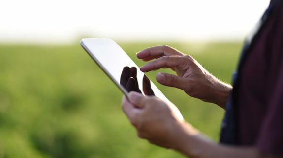 Producer using a mobile device on farm